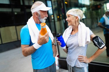 Şehirde koşan olgun bir çift dışarıda koşuyor. Koşucular dışarıda antrenman yapıyor.