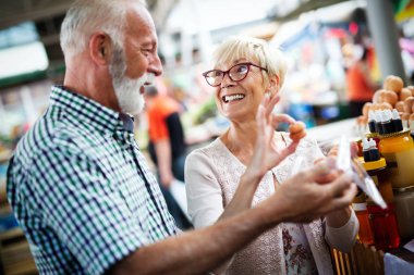 Yaşlı çift pazarda sebze ve meyve alışverişi yapıyor. Sağlıklı beslenme.