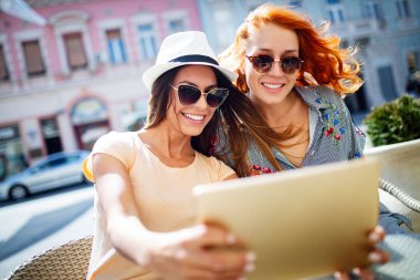 Tatil, turizm ve internet - cafe dışında tablet pc bakarak güzel genç kızlar