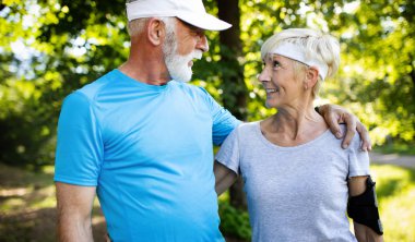 Aktif yaşlı çift sağlıklı yaşam için parkta çalışan