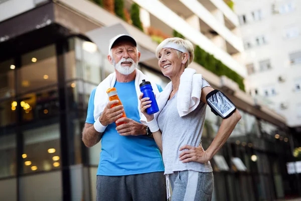 Healthy senior couple jogging in the city at early morning