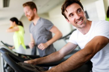 Spor salonunda egzersiz yapan bir grup sağlıklı genç.