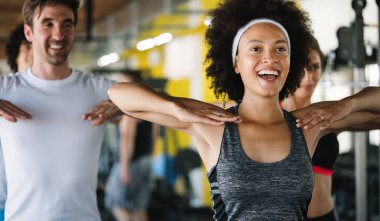 Spor salonundaki neşeli forma takımının fotoğrafı.