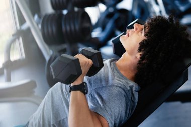 Sağlıklı yaşam ve spor salonu konsepti. Spor fitness kulübünde çalışan zinde bir genç.