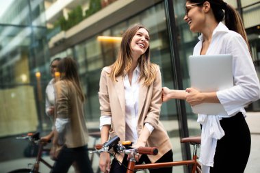 Mutlu iş adamları dışarıda yürürken tartışıyor ve gülümsüyor.