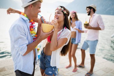 Genç ve eğlenceli insanlar sahilde yazın tadını çıkarıyor.