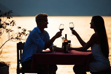 Mutlu genç çift yaz akşamında romantik bir akşam yemeği yiyor.