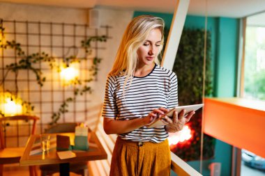 Sosyal ağlarda blog yazmak için taşınabilir bilgisayar kullanan neşeli genç bir kadının portresi