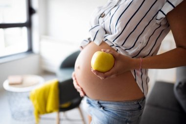 Hamile genç bir kadın sağlıklı bir bebek bekliyor.