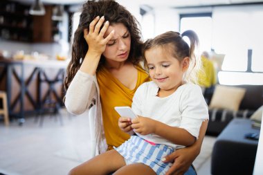 İnsanlar, çocuklar, teknoloji ve bağımlılık kavramı. Evde akıllı telefonları olan küçük bir kız.