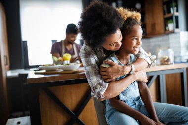 Mutlu Afro-Amerikan ailesi mutfakta sağlıklı organik yiyecekler hazırlıyor.