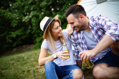 Genç çift yaz macerası gezisinde çadırda kamp yapıyor.