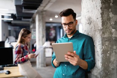 İş yerinde teknolojiyi kullanan genç bir iş arkadaşı, dijital tablet