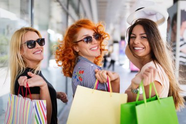 Alışveriş merkezinde alışveriş yaparken alışveriş yaparken alışveriş poşetleri ile kadın arkadaşlar, mağazalar