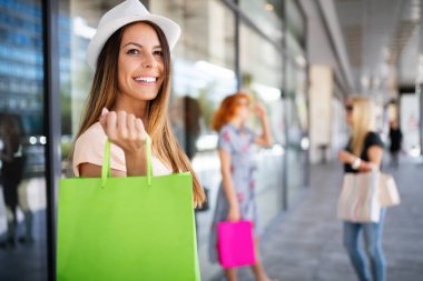 Alışveriş merkezinde alışveriş yaparken alışveriş yaparken alışveriş poşetleri ile kadın arkadaşlar, mağazalar