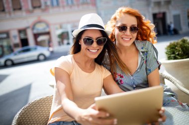 Tatil, turizm ve internet - cafe dışında tablet pc bakarak güzel genç kızlar