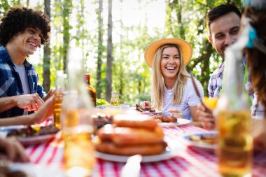 Arkadaşlar doğada barbekü yaparken eğleniyorlar.