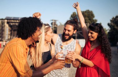 Bir grup mutlu arkadaş müzik festivalinde eğleniyor.