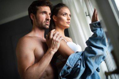 Yatak odasında birbirine sarılan şehvetli bir çiftin portresi.