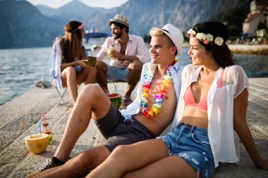 Bir grup arkadaş sahilde dans edip eğleniyorlar. Plajda yaz tatili partisi