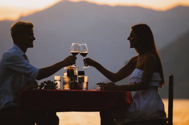 Tropikal tatil akşam yemeği sırasında tost genç romantik çift