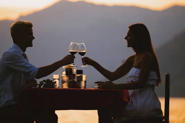 トロピカルリゾートでのディナー中に乾杯する若いロマンチックなカップル — ストック写真