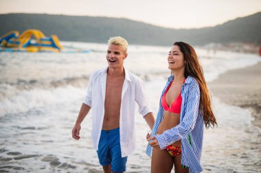 Sahilde birbirine aşık gülümseyen bir çift.