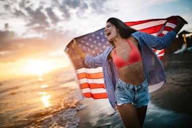 Mutlu kadın gülümseyip plajda koşarken bağımsızlık gününü kutluyor ve Amerika 'da özgürlüğün tadını çıkarıyor.