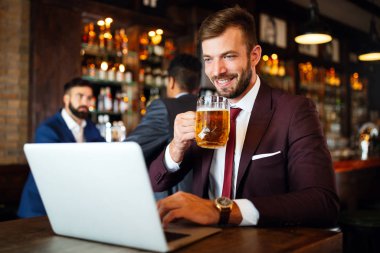 Kafede oturan başarılı bir girişimcinin portresi bir dizüstü bilgisayar üzerinde çalışıyor..