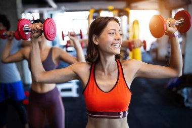 Spor salonunda egzersiz yapan çekici ve formda bir kadının görüntüsü.