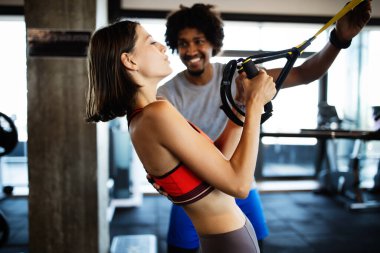 Spor salonunda fit insanlarla egzersiz yapan beden eğitimi hocası..