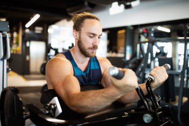 Spor salonunda egzersiz yapan yakışıklı bir genç.