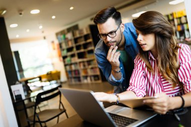 Öğrenci beyin fırtınası çalışıyor. Kütüphane arkadaşları takım çalışması kavramını analiz ediyor.