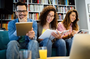 Mutlu genç üniversite öğrencileri birlikte okuyorlar. Üniversitede bir grup çok ırklı insan