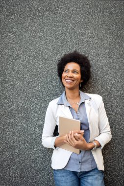 Güzel, mutlu, profesyonel bir iş kadını. Tabletle mutlu gülümsüyor.