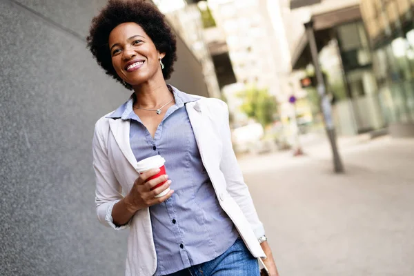 Smiling happy business woman, lawyer walking with coffee outdoor