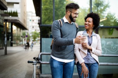 Mutlu iş adamları, öğrenciler eğleniyor, gülümsüyor, şehirde konuşuyorlar.