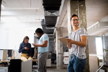 İş yerinde teknolojiyi kullanan genç bir iş arkadaşı, dijital tablet