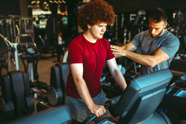 Sobrepeso Jovem Gordinha Homem Exercitando Ginásio Com Personal Trainer — Fotografia de Stock