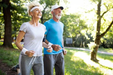 Güneşli ormanda dışarıda çalışan güzel yaşlı çift