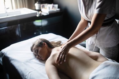 Masör spa salonunda kadın vücuduna masaj yapıyor. Güzellik tedavi konsepti.