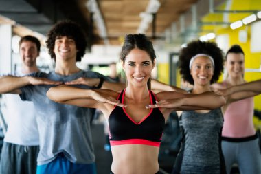 Güzel fit insanlar, spor salonunda birlikte egzersiz yapan arkadaşlar.