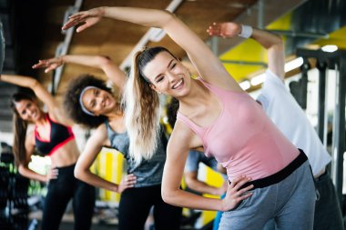 Spor salonundaki mutlu bir grup sporcu. Bir fitness kulübünde yaşam tarzı ve spor konseptleri