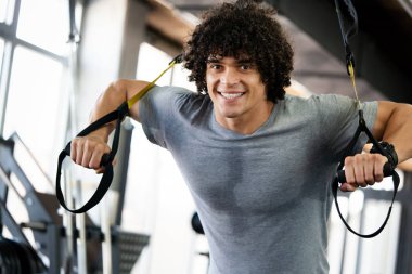 Sağlıklı yaşam ve spor salonu konsepti. Spor fitness kulübünde çalışan zinde bir genç.