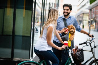 Küçük köpekleri olan, gülen genç bir çift şehirde konuşuyor.