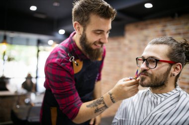 Berber dükkanında kuaförü ziyaret eden mutlu genç adam..