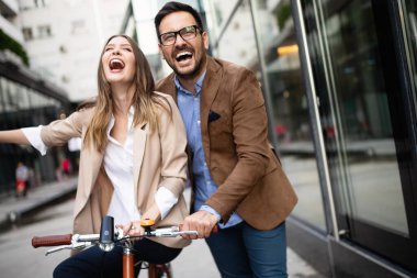 Genç mutlu çift şehirde eğleniyor ve bisiklete biniyor.