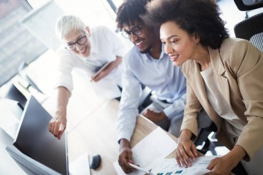 İş yerinde tam konsantrasyon. Ofis masasında birlikte çalışan ve iletişim kuran iş adamları grubu