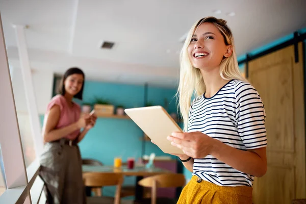 Portrait of smiling beautiful woman in office with tablet