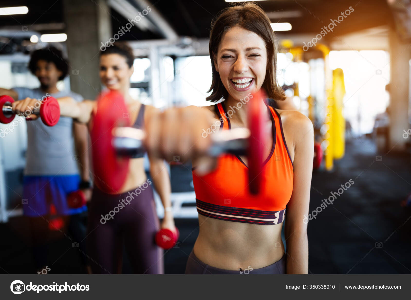 Beautiful fit people working out in gym together Stock Photo by nd3000